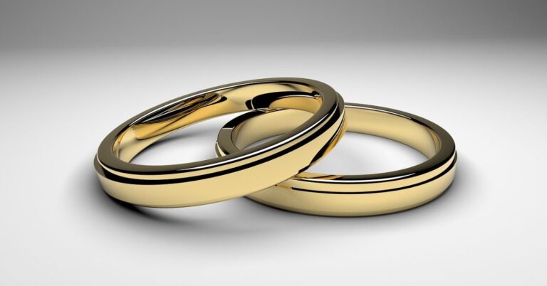 Two gold wedding rings resting on a white background, symbolizing love and commitment in a timeless design.